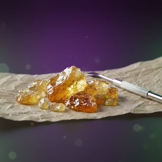 Hemp-derived THC-A shatter concentrate on parchment paper with dab tool